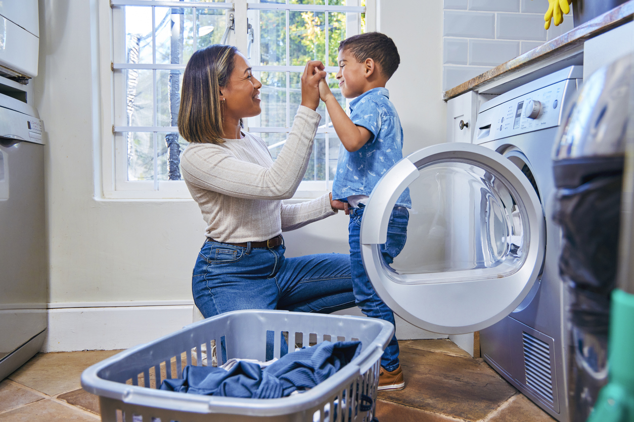 Shot of a little boy helping his mother do the laundry