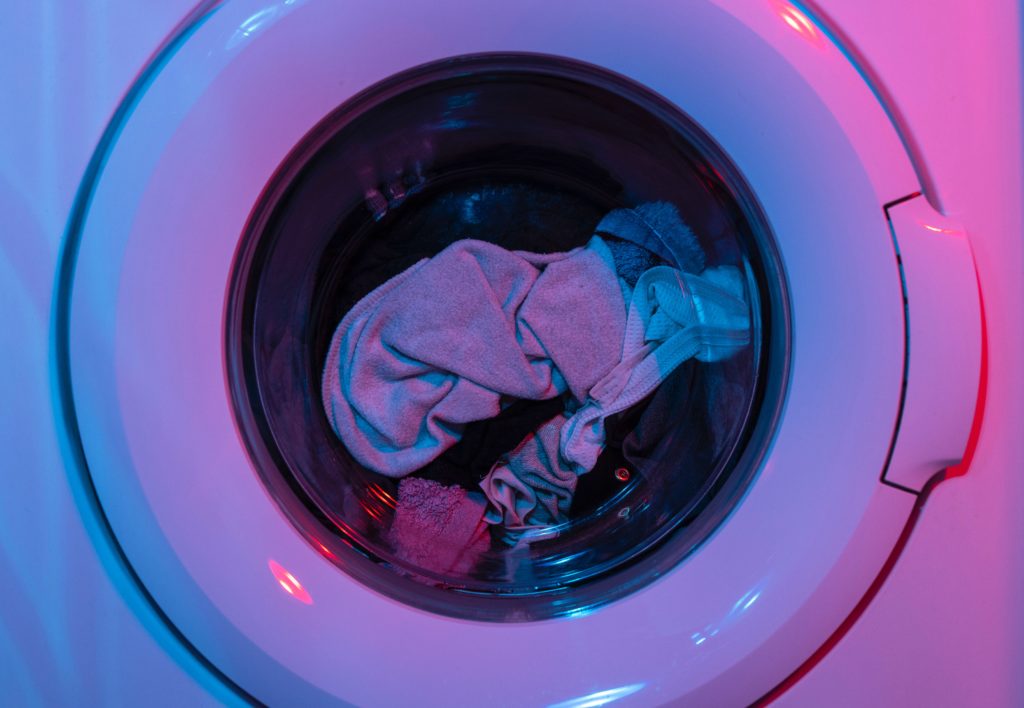A dryer with towels tumbling inside it